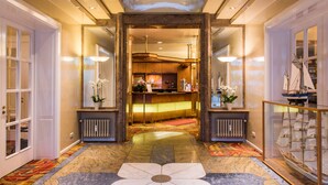 A hotel lobby with a marble floor, a reception desk, and a ship model. - Hotel Vorbach (Hamburg)