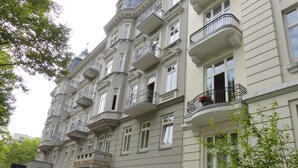 A multi-story hotel with balconies, a central entrance, and a garden area. - Hotel Vorbach (Hamburg)