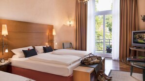 A hotel room with two beds, a TV, a desk, and a window with curtains. - Hotel Vorbach (Hamburg)