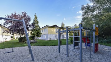 Guests can enjoy a fun outdoor playground with a swing set and climbing structure.