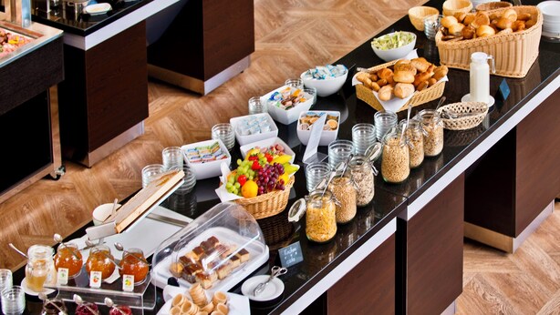 A buffet with various food items and condiments. - Atrium Hotel Amadeus (Osterfeld)