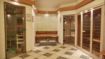 Un'area spa con una panca in legno, un lavabo e una cabina doccia in vetro.