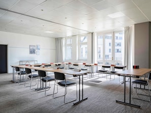 A conference room with a long table, chairs, and large windows. - ibis Paris Porte De Bercy (Charenton-le-Pont)