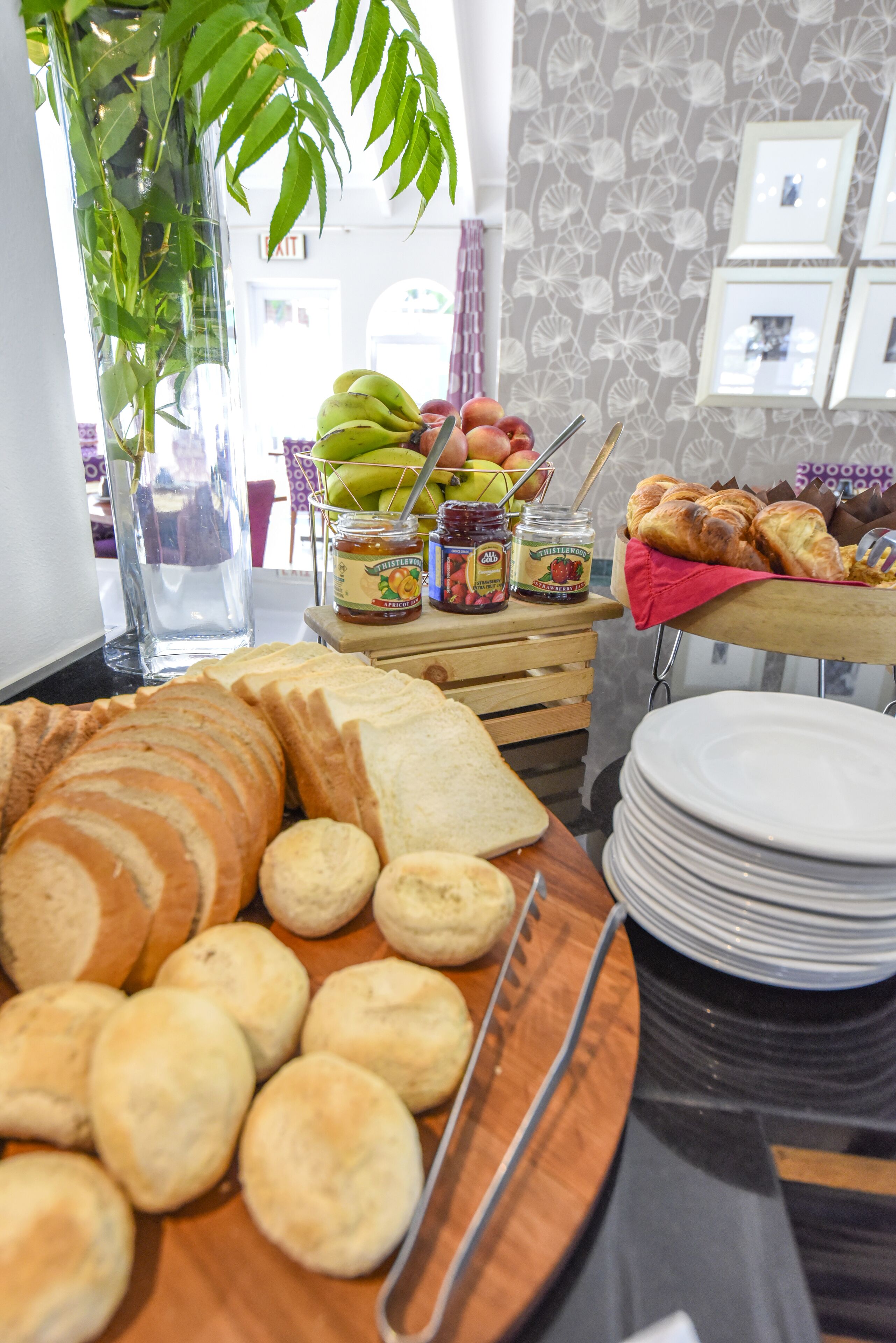 Un buffet de petit-déjeuner comprenant du pain, des viennoiseries et des confitures.