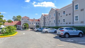 A parking lot with several cars, a building with a red roof, and a sign that reads "Motel." - Mercure Johannesburg Randburg Hotel (Randburg)