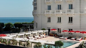 A hotel with a pool area, sun loungers, and umbrellas. - Regina Experimental Biarritz (Biarritz)