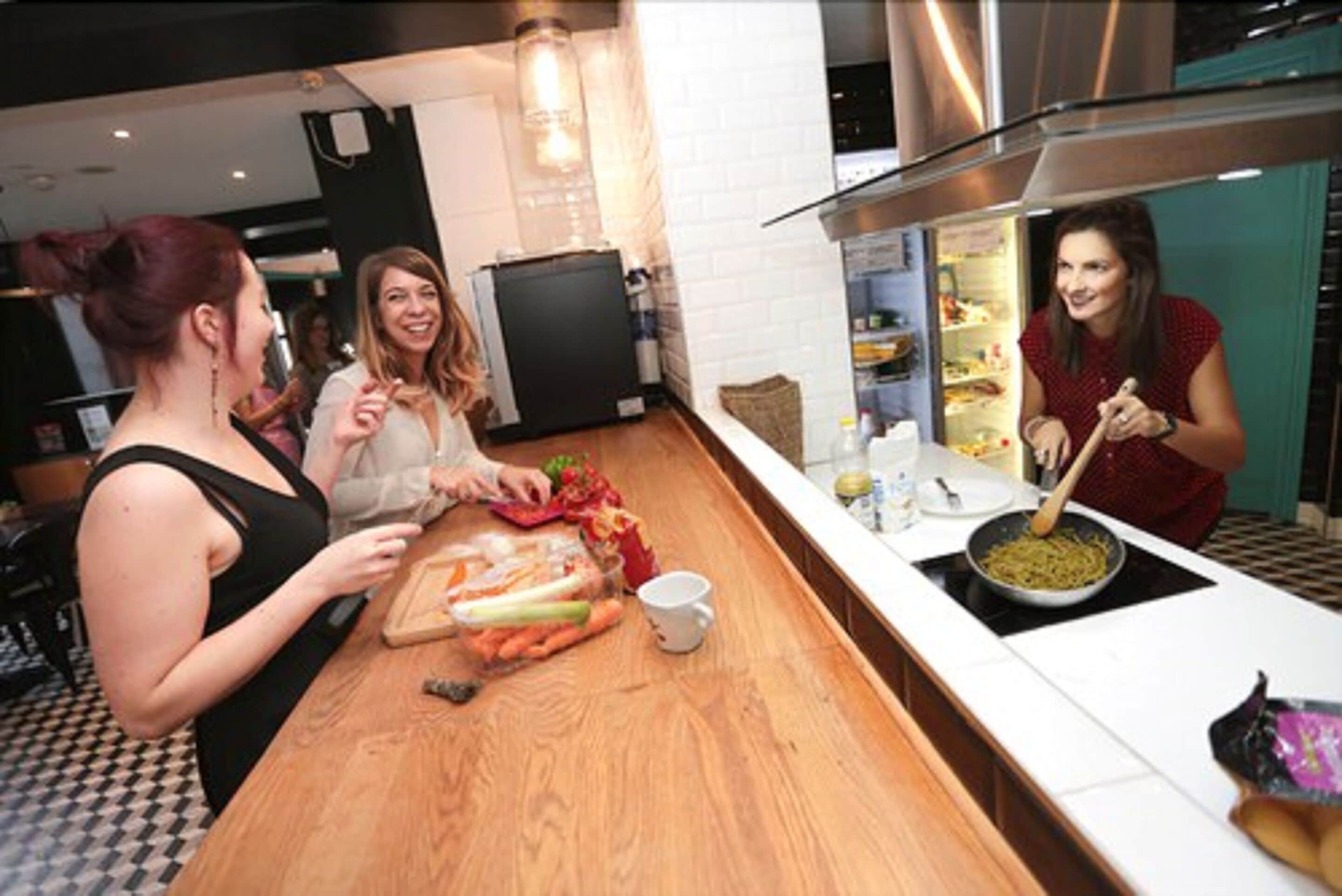 A modern kitchen with a wooden countertop, a stove, and a refrigerator.