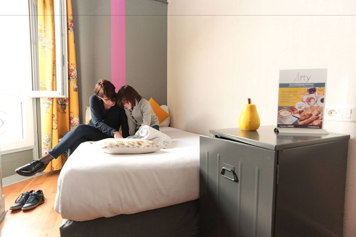 Ein Schlafzimmer mit einem Bett, einem Schreibtisch und einem Poster an der Wand.