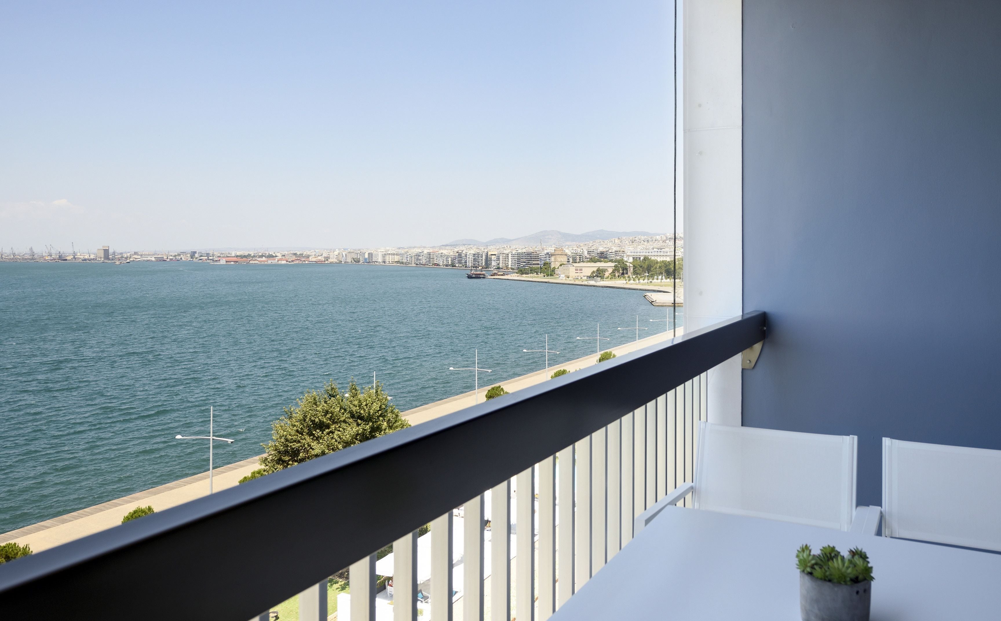 A balcony with a view of a cityscape and a body of water.