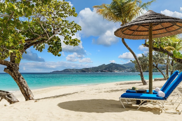 On the beach, white sand, sun loungers, beach umbrellas