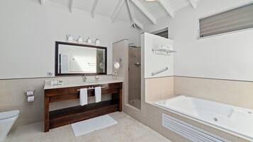 Un baño moderno con un espejo grande, un tocador de madera, una bañera y una zona de ducha.