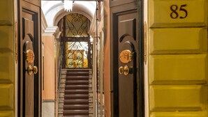 A grand staircase leading to a door marked with the number 85, flanked by ornate doors and a decorative metal railing. - The Inn at the Spanish Steps (Rome)