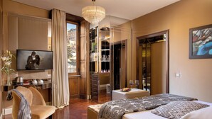 A hotel room with a bed, a desk, a chair, a television, and a wardrobe. - The Inn at the Spanish Steps (Rome)