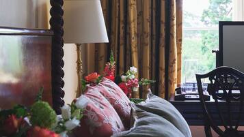 Habitación de hotel con cama, lámpara, silla y ventana con cortinas.