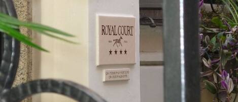 A sign with the text 'ROYAL COURT' and a horse symbol, indicating a hotel or establishment named Royal Court.