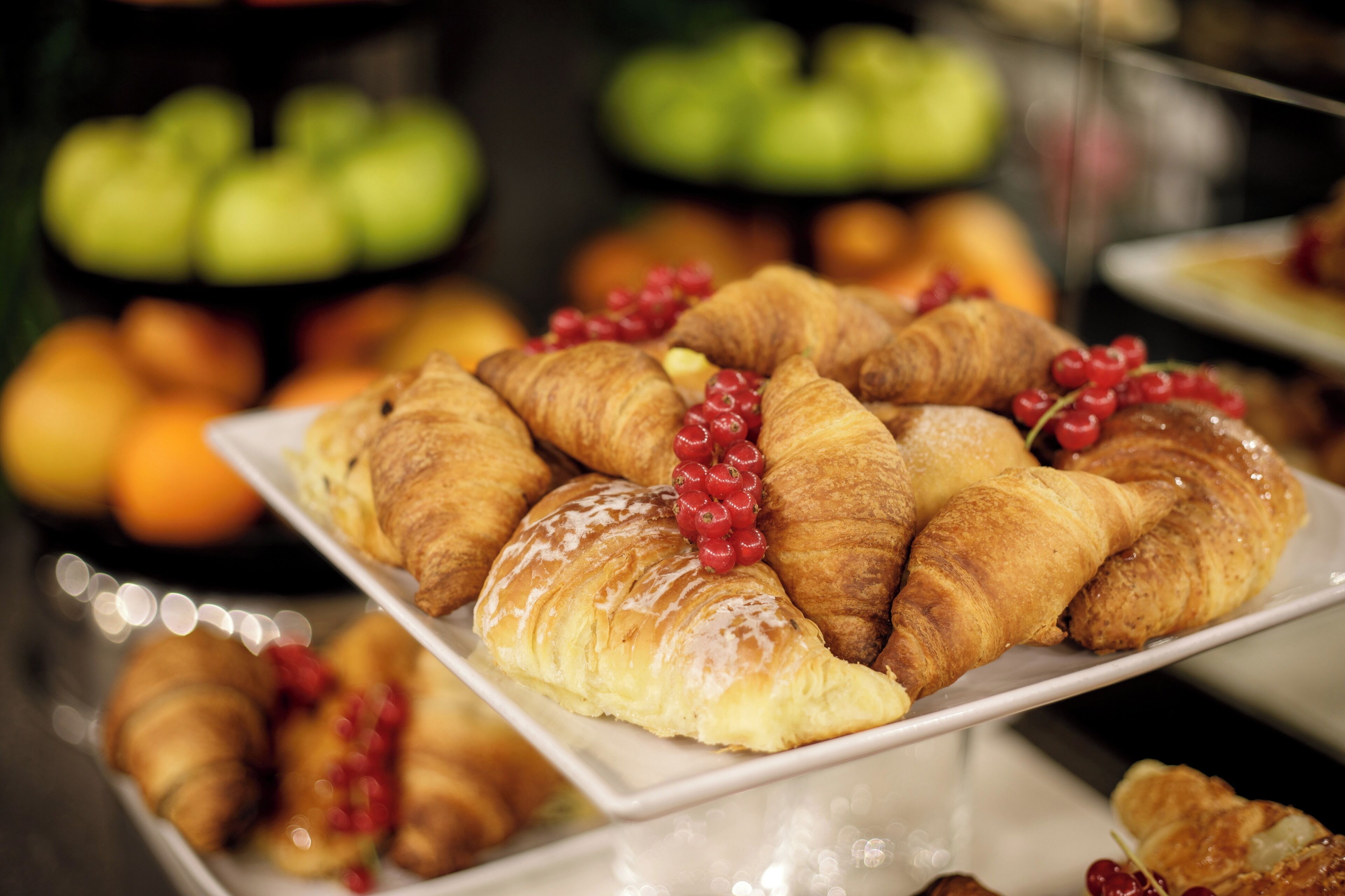 A buffet with croissants and berries.