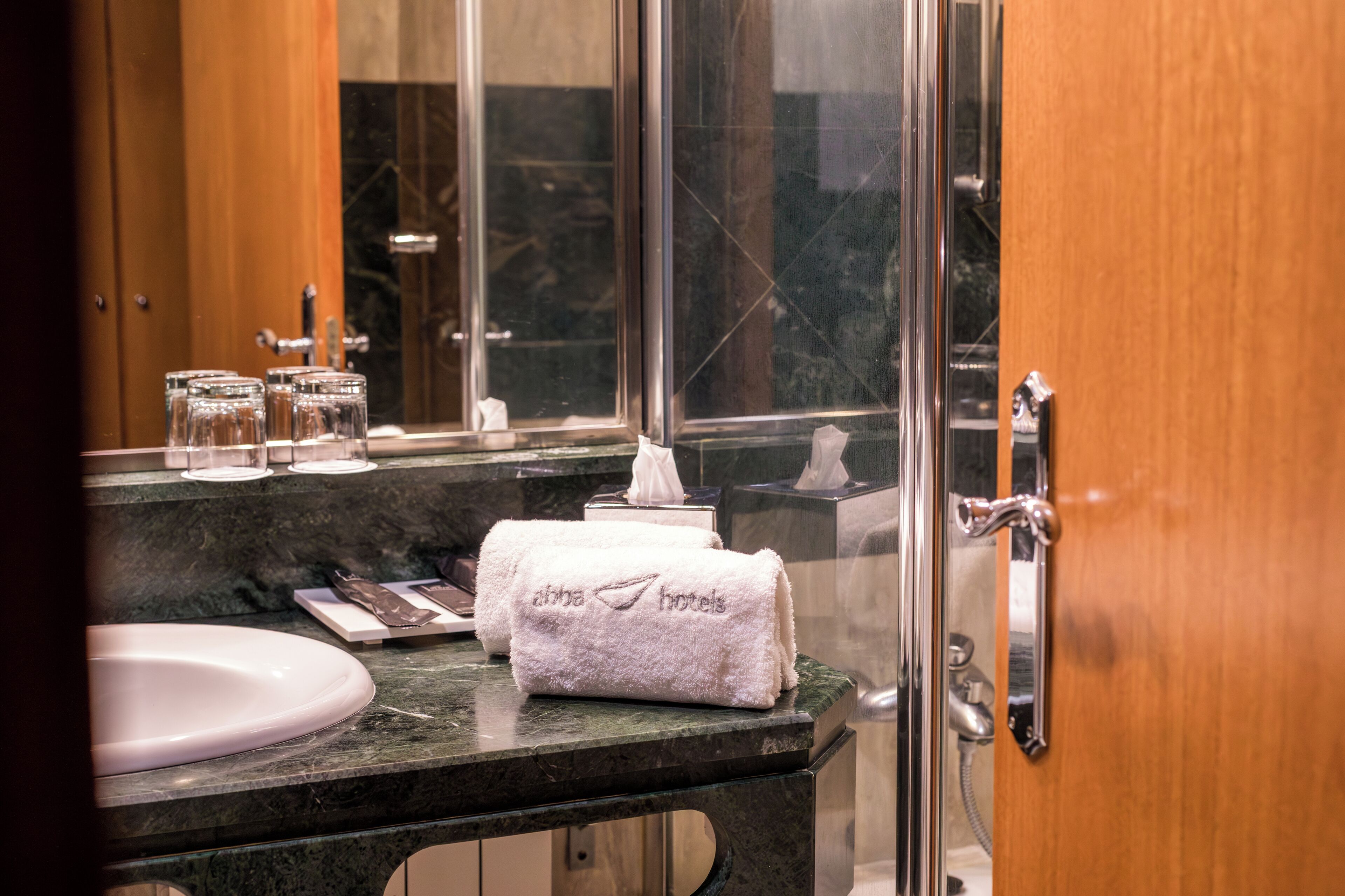 Un baño con encimera de mármol, un lavabo, una toalla y un espejo.
