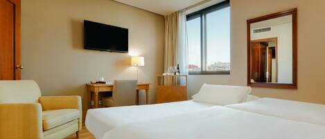 A hotel room with two beds, a desk, a chair, a TV, and a window with a city view.