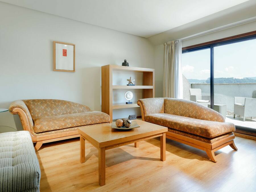 Ein modernes Wohnzimmer mit zwei Sofas, einem Couchtisch und einem Holzregal.