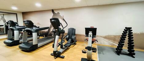 A gym with treadmills, a stationary bike, and a weight bench.