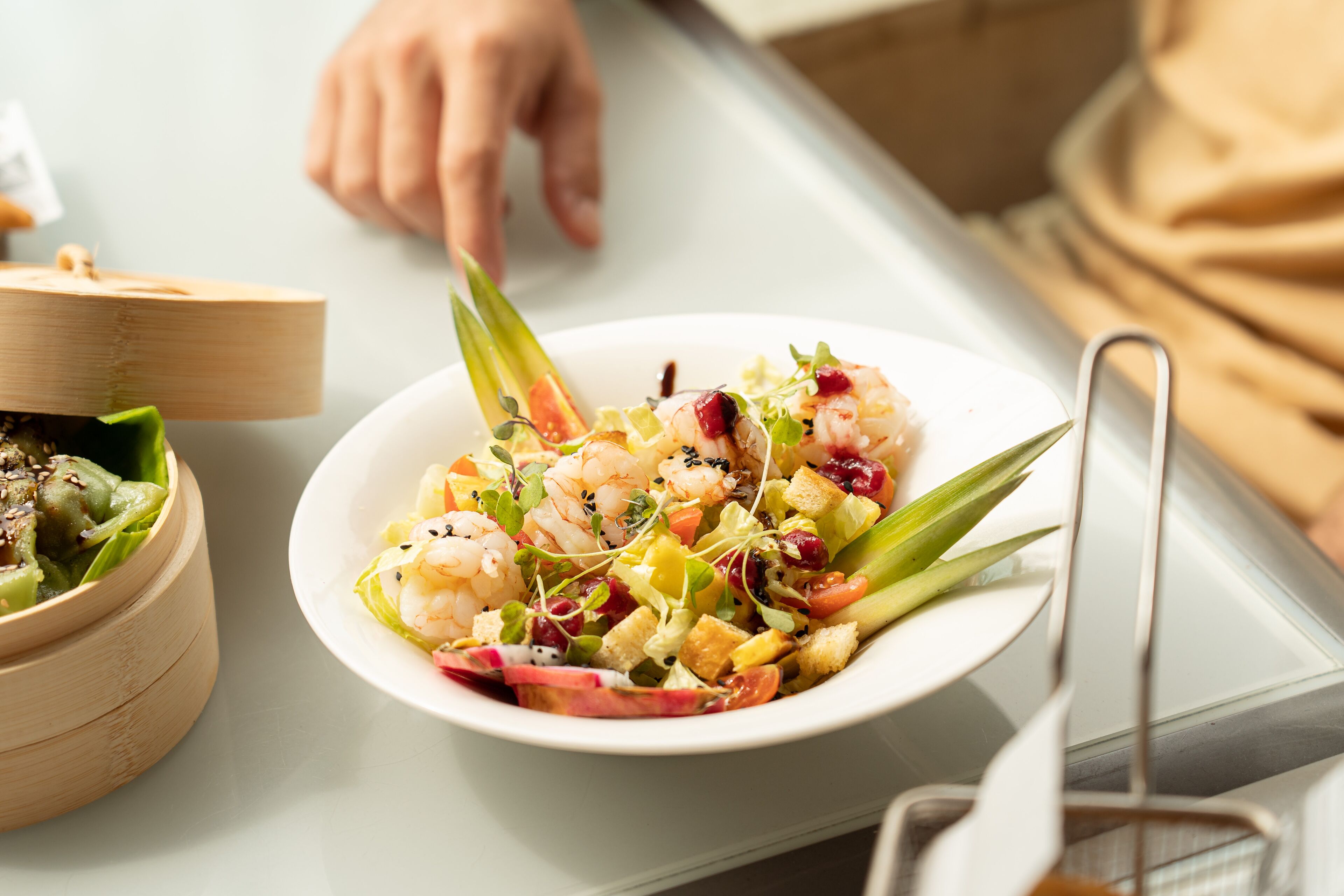 A plate of shrimp salad with various vegetables and herbs.