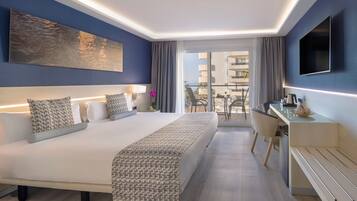 Una habitación de hotel moderna con una cama grande, un escritorio y un balcón con vistas.