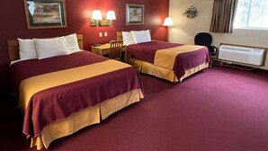 A hotel room with two beds, a desk, a chair, a window with curtains, and wall-mounted lamps. - Americas Best Value Inn Suburban Motel (Emmetsburg)