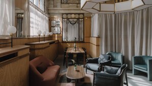 A modern interior with a wooden dining table, leather chairs, and a large window with curtains. - Club Quarters Hotel London City, London (London)