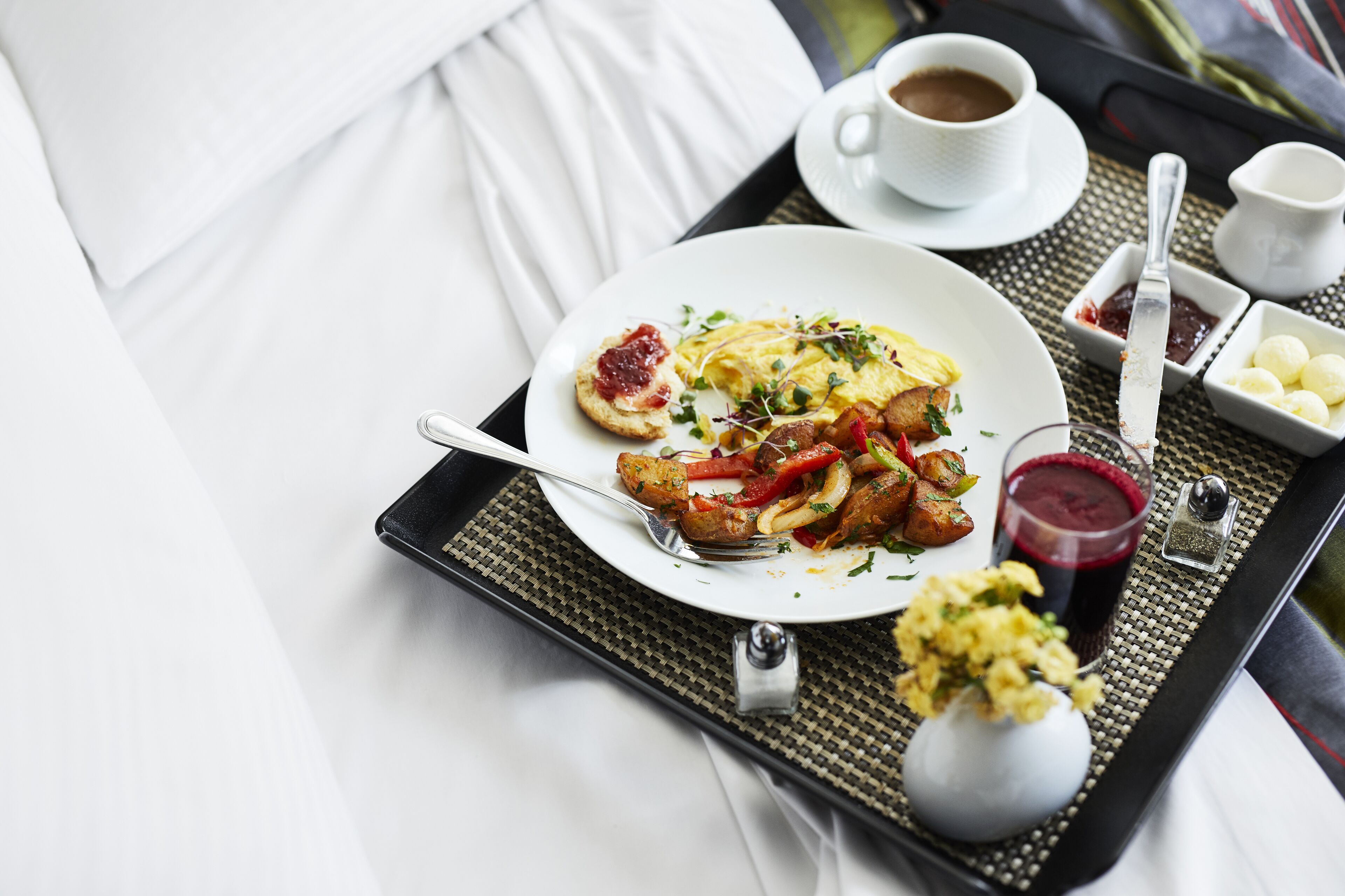 A tray with breakfast items including eggs, toast, and a drink, set on a table with a white tablecloth.