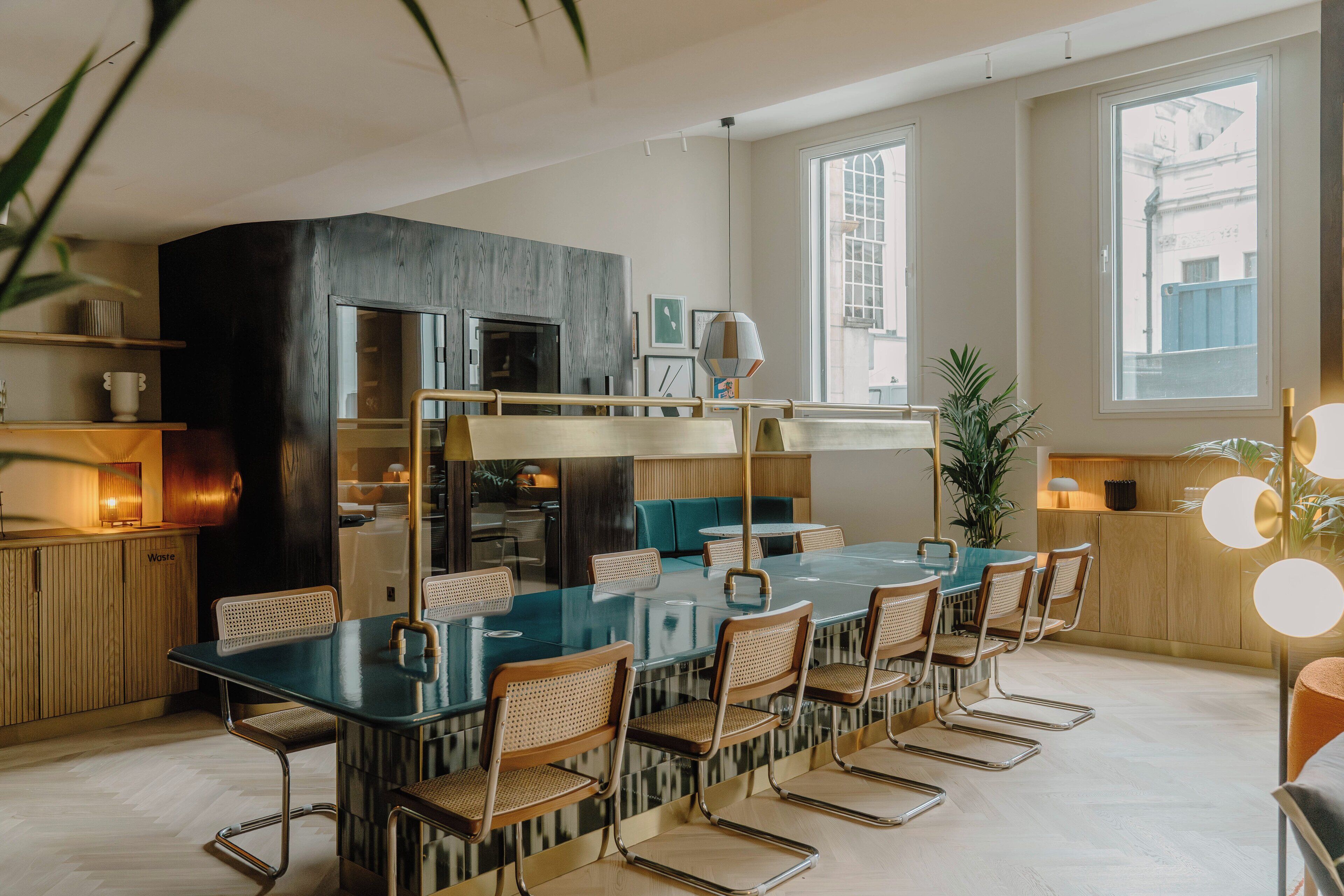 A modern kitchen with a large island, wooden cabinets, and a dining area with a glass table and chairs.