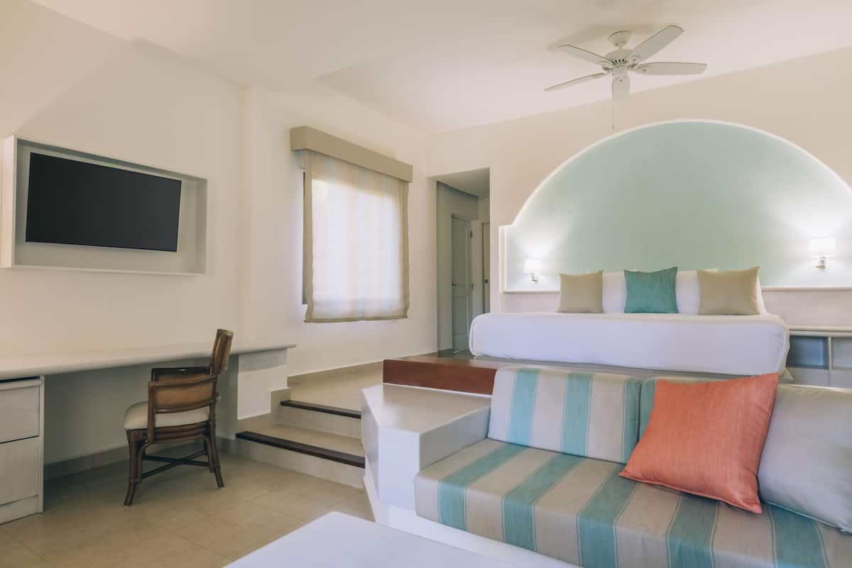 A modern hotel room with a bed, a desk, and a chair.