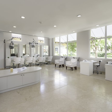 A modern spa with a large reception area, multiple treatment rooms, and a large window providing natural light.
