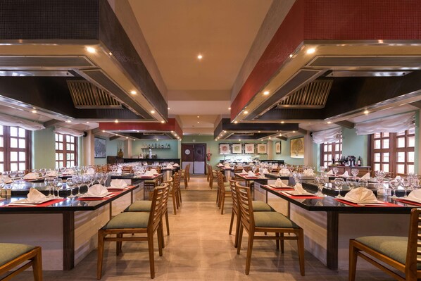 A restaurant with multiple dining tables set with white napkins, glasses, and cutlery. - Iberostar Waves Costa Dorada - All Inclusive (Puerto Plata)
