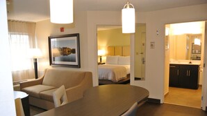 Une chambre d’hôtel comprenant un coin repas, un lit, une salle de bain et une kitchenette.