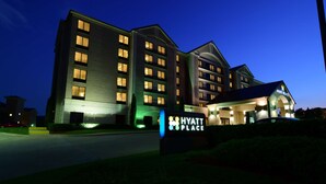 Un hôtel à plusieurs étages, reconnaissable à son enseigne bien visible indiquant « Hyatt Place ».