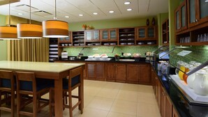 Un restaurant avec des meubles en bois, un buffet et un mur recouvert de carreaux.