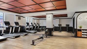 Un gimnasio con cintas de correr, elípticas y bicicletas estáticas.