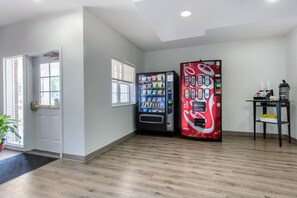 Quarto com porta, janela, máquina de vendas e cafeteira.