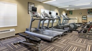 Une salle de sport équipée de tapis de course, d’un banc et d’un banc de musculation.