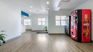 Een modern interieur met een automaat, houten vloeren en een potplant.