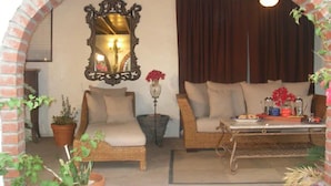Una sala de estar acogedora con un arco de ladrillo, un sofá, una silla, una mesa y plantas en macetas.