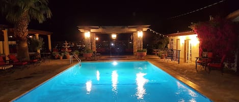 Una piscina al aire libre, sillones reclinables de piscina