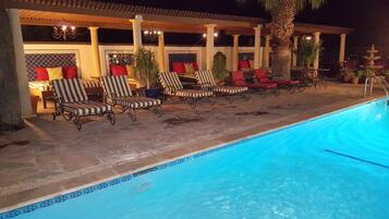 A poolside area with lounge chairs and a pool.