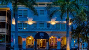 Un hôtel historique doté d’une entrée imposante, de nombreux balcons et d’une façade bien éclairée.