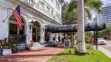 A historic building with an American flag, a covered outdoor seating area, and a sign for 'The Cordova Inn'.