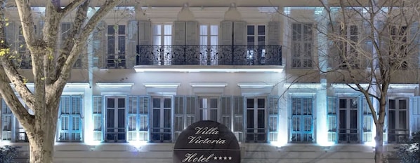 Hotel Villa Victoria, con una fachada imponente, múltiples ventanas y un balcón con barandillas ornamentales.