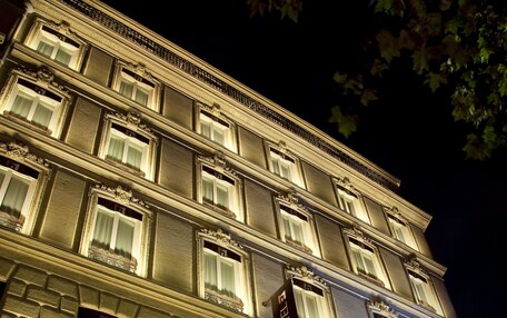 A multi-story hotel with illuminated windows and a sign indicating it is a hotel.
