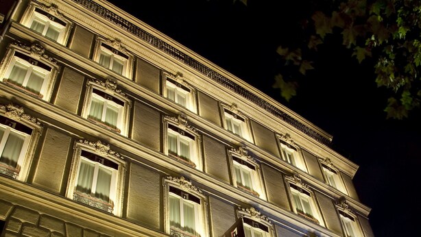 Een meerhoog hotel met verlichte ramen en een bord waarop staat dat het een hotel is.