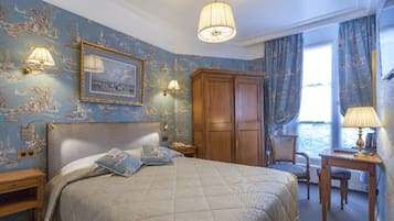 Ein Schlafzimmer mit Bett, Kleiderschrank, Schreibtisch und Stuhl.