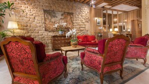 A room with a stone wall, wooden furniture, and a large mirror.